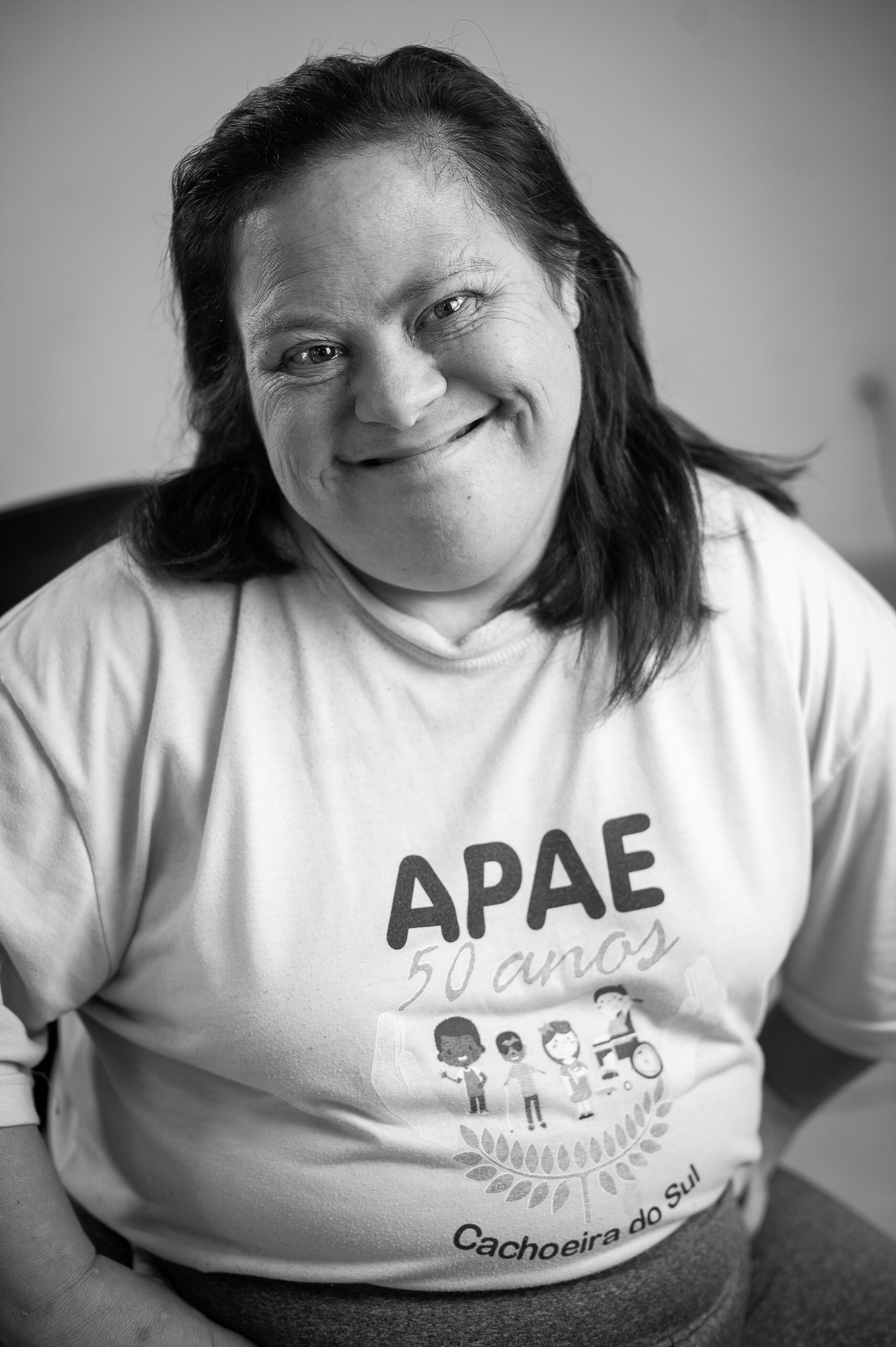 Mulher sorrindo com camiseta da APAE 50 anos