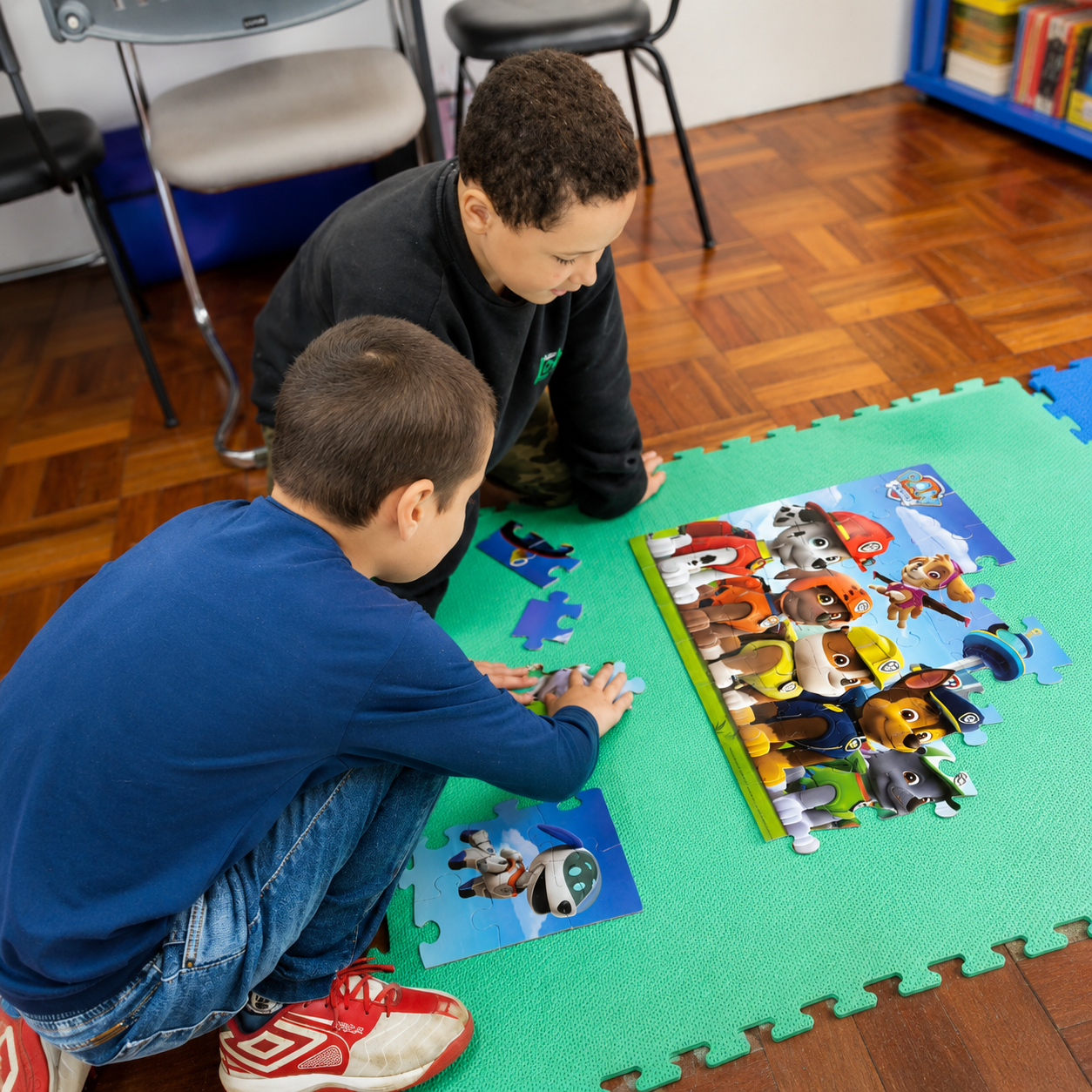 Dois meninos montando quebra-cabeça no tapete